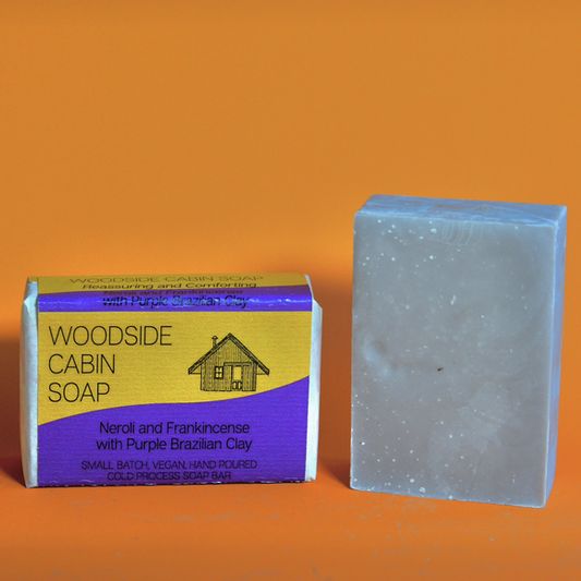 Woodside Cabin Soap bar and packaging on an orange background