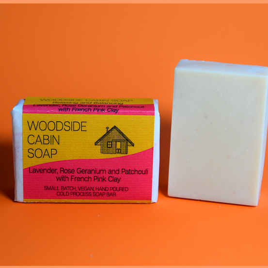 Woodside Cabin Soap bar and packaging on an orange background